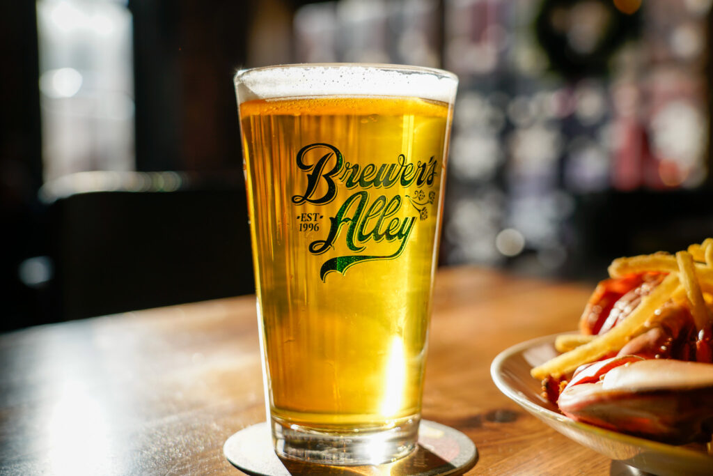 A pint glass of golden beer labeled 
