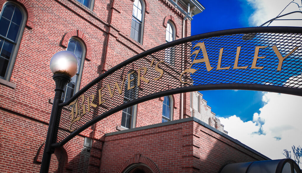 A curved metal archway with gold lettering reads 